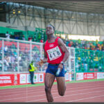 Male track athlete preparing for a sprint, showing pre-race focus and readiness.
