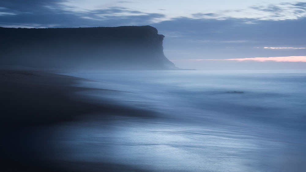 A photo illustrating visual mass balance, showing how bright water balances out a dark cliff and beach.