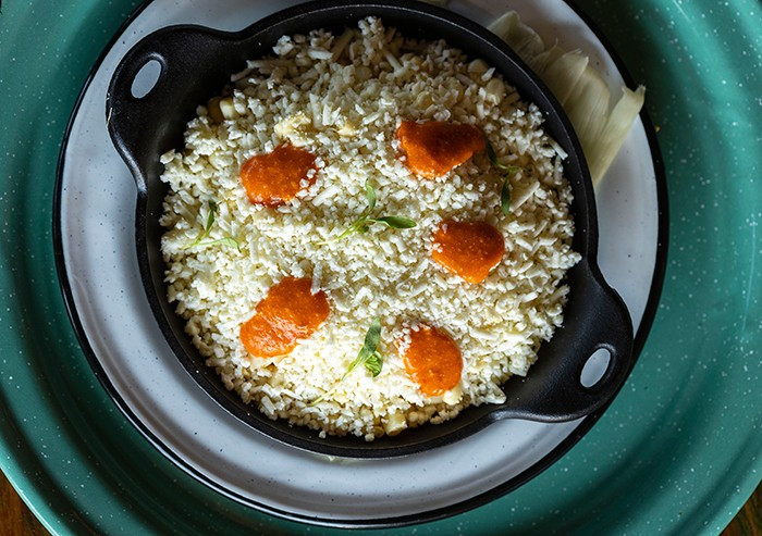 An artful presentation of A'Verde's street-charred corn, showcasing vibrant colors and textures with a sprinkle of togarashi pepper, enhancing its visual appeal.