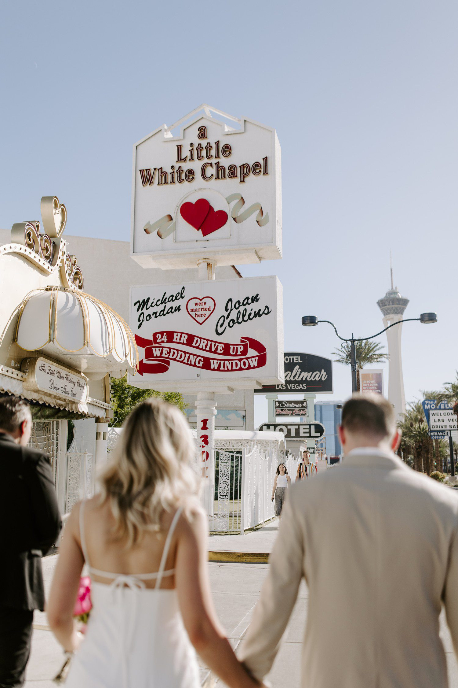 Couple walking to A Little White Chapel, capturing the charm and excitement of their special day