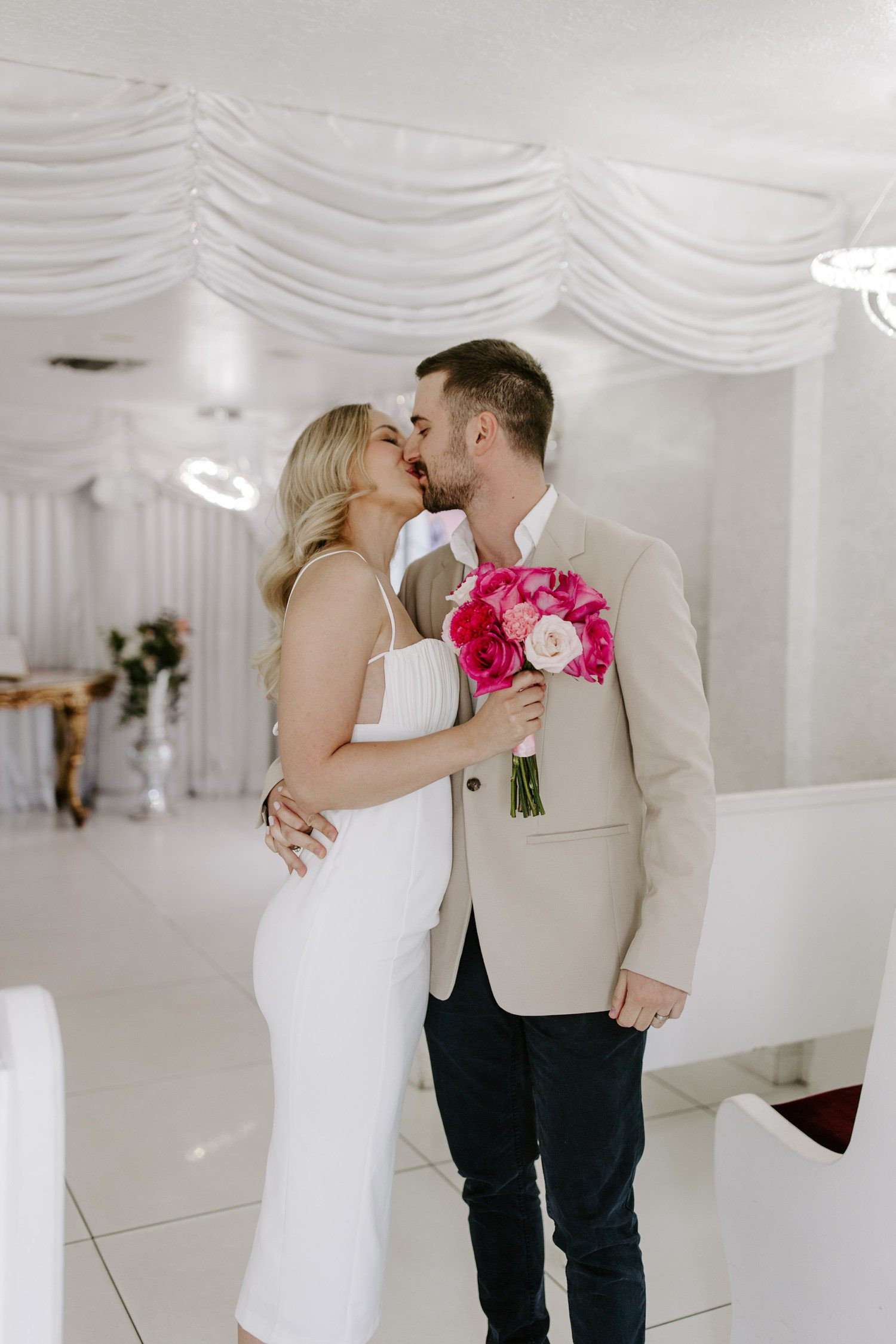 Couple kissing while walking down aisle at wedding chapel ceremony, capturing the joy and celebration of the moment
