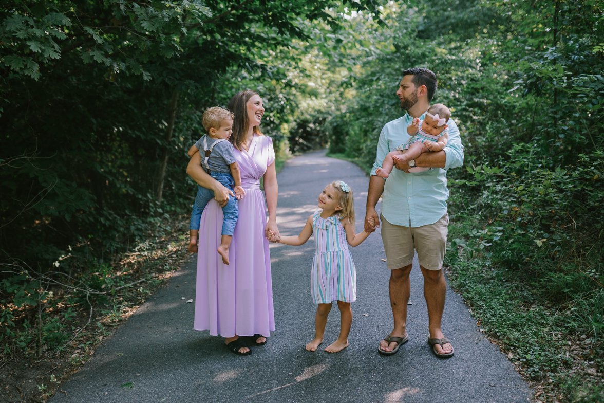 Family of 5 standing together in green location