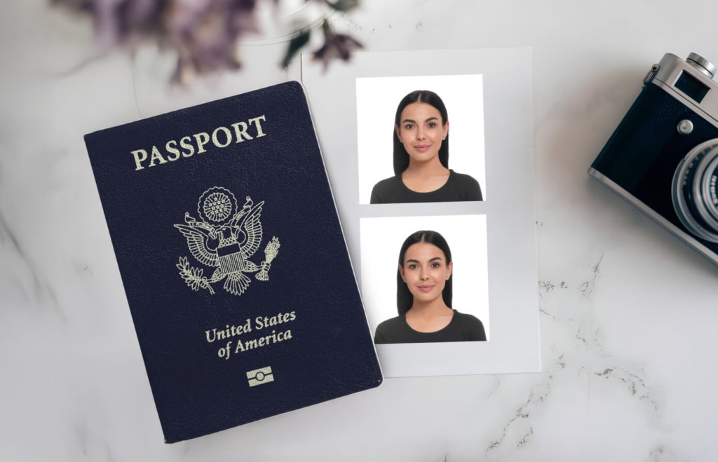 A printed sheet with two passport photos placed beside a U.S. passport and camera